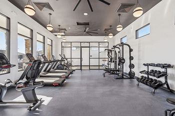 A spacious gym with treadmills, elliptical machines, and weightlifting equipment.